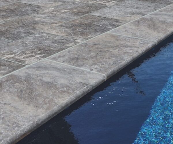Margelle travertin silver bord arrondi 61x33x3 devant une piscine